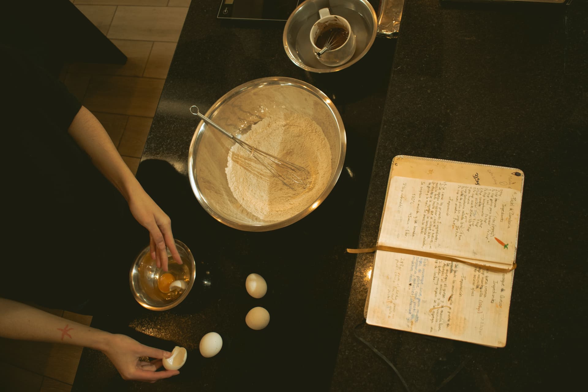 Baking ingredients and an open recipe book on a kitchen counter